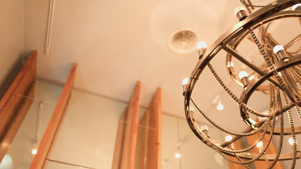 Low angle shot of a rotating steampunk chandelier made from bicycle chains and metal