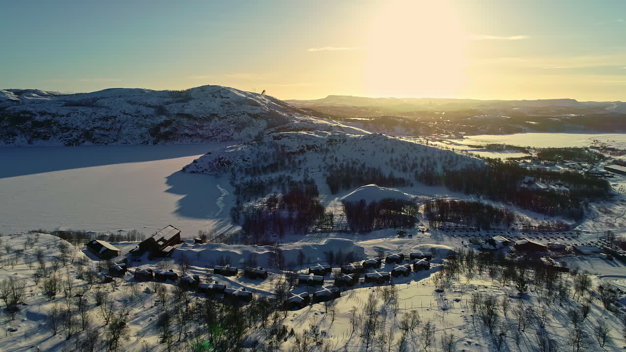 vista aérea que muestra el hermoso paisaje invernal nevado y la luz del atardecer en el snowhotel kirkenes y las cabañas de la aurora boreal gamme