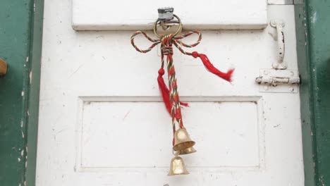 holiday bells hanging on a rustic white door