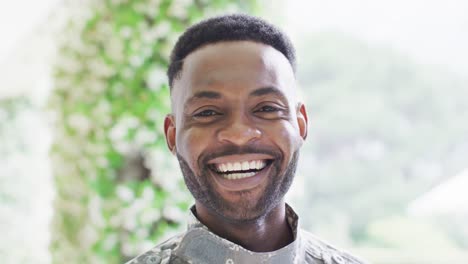 portrait of happy african american man smiling outdoors, slow motion