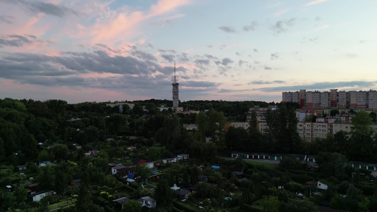 área urbana con torre de televisión y edificios durante la noche