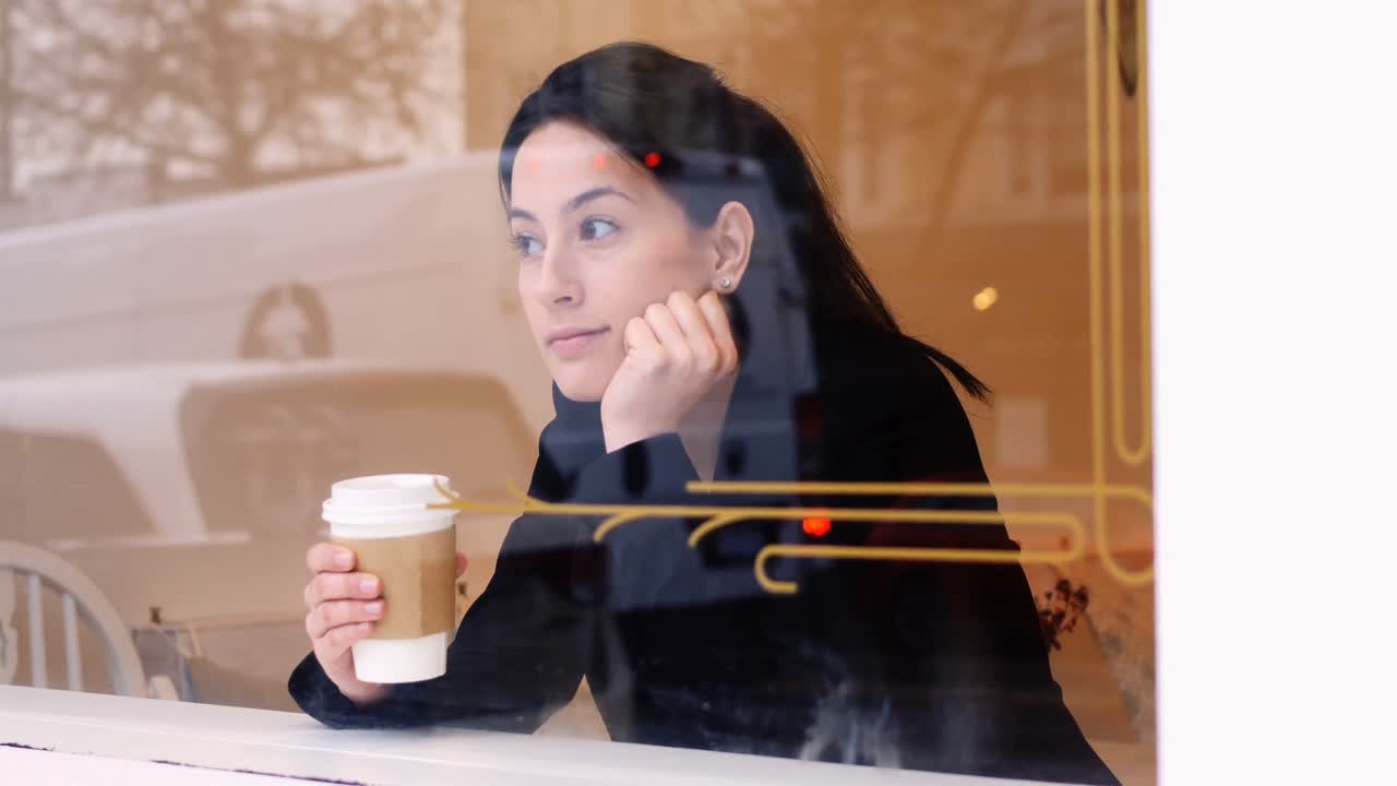 mujer mirando por la ventana mientras toma café