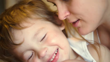 madre acariciando a su hijo pequeño mientras canta una canción
