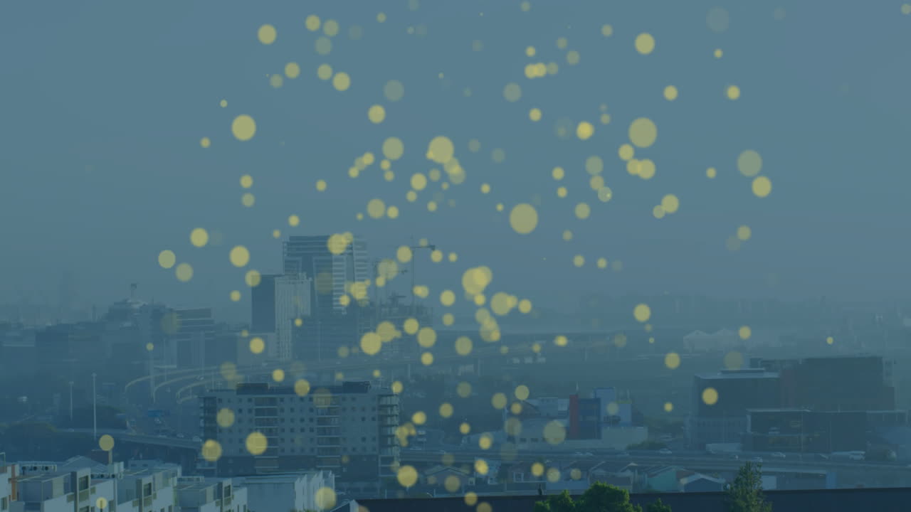 Floating yellow light particles over cityscape with tall buildings in animation