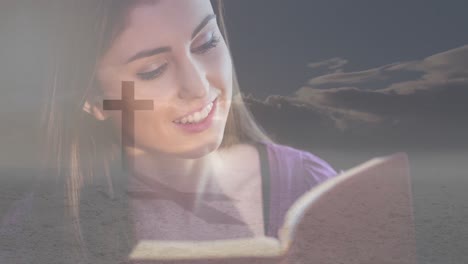 animation of caucasian woman reading holy bible and crucifix at sunset