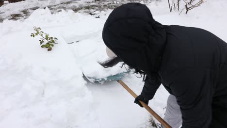 Mujer-Determinada-Limpiando-Nieve-Usando-Pala-En-Invierno