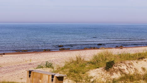 garbage bags and wooden trash container on sandy beach at uzavas ieteka, latvia.