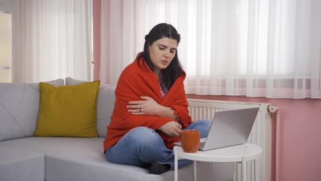 the woman is cold and trying to use a laptop.