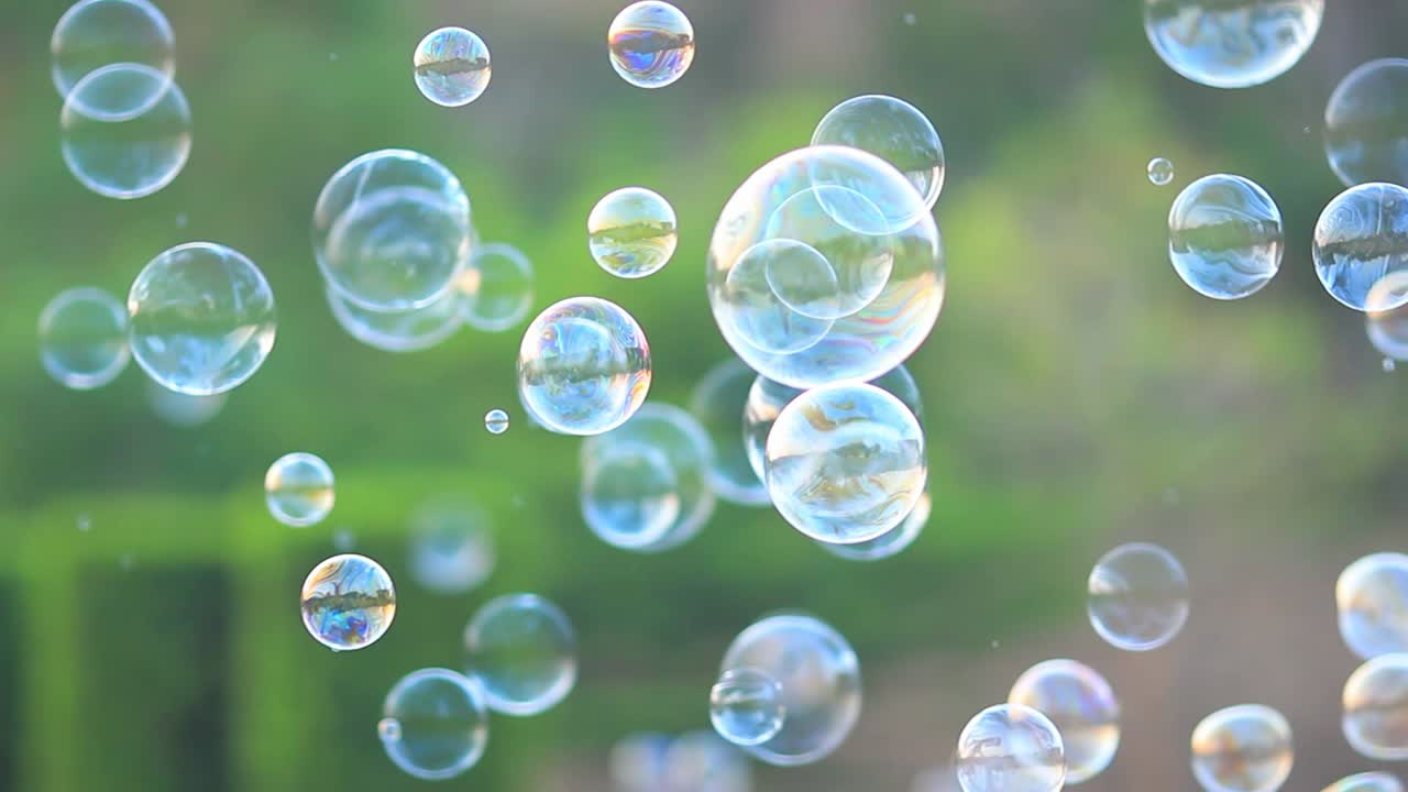 어린이와 어린이를 위한 자연 녹색 흐릿한 보케 배경으로 공중에 떠다니는 비누 거품