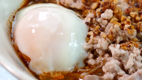 thai styled tom yum noodles contained with egg noodles, minced pork cake, pork liver and intestine, bean sprouts, spices and grounded peanut, one of the favourite street food in thailand