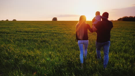 una joven pareja casada camina por un hermoso prado al atardecer 2