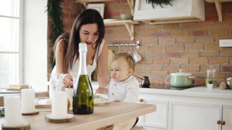happy mother giving cookies to her little son boy in the kitchen, happy time together