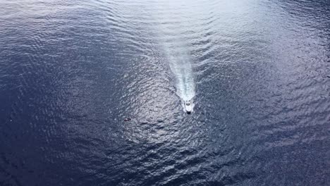 drone shot of luxury motorboat in ocean waters near marina