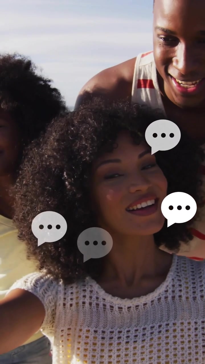 Video verticale: Donna che tiene il telefono, inizia un selfie di famiglia in spiaggia, con icone di chat che salgono per i social.