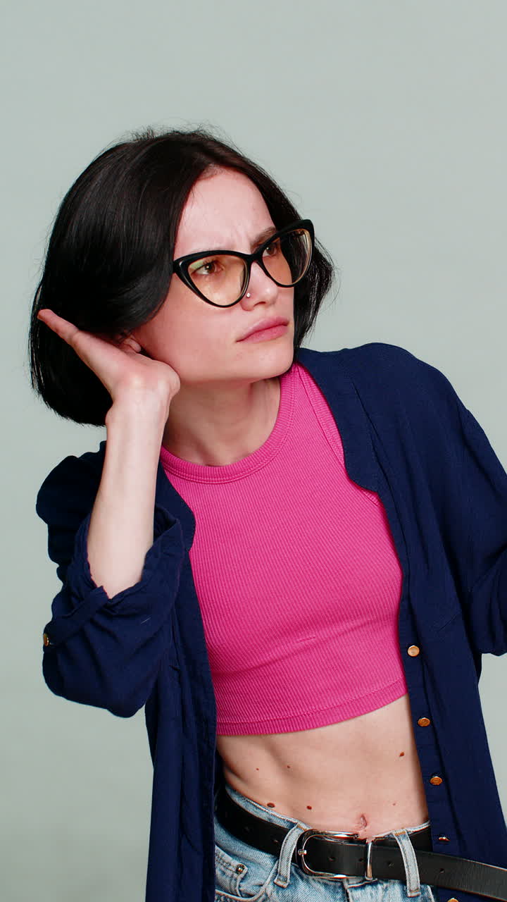 Woman leaning forward placing hand to ear asking to repeat clearly indicating difficulty hearing