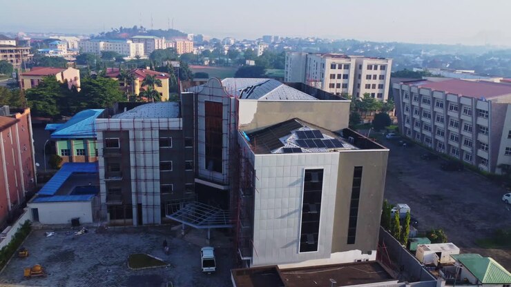 Splendida ripresa aerea di un edificio per uffici con pannelli solari fotovoltaici sul tetto in fase di ristrutturazione nella città di Abuja, Nigeria