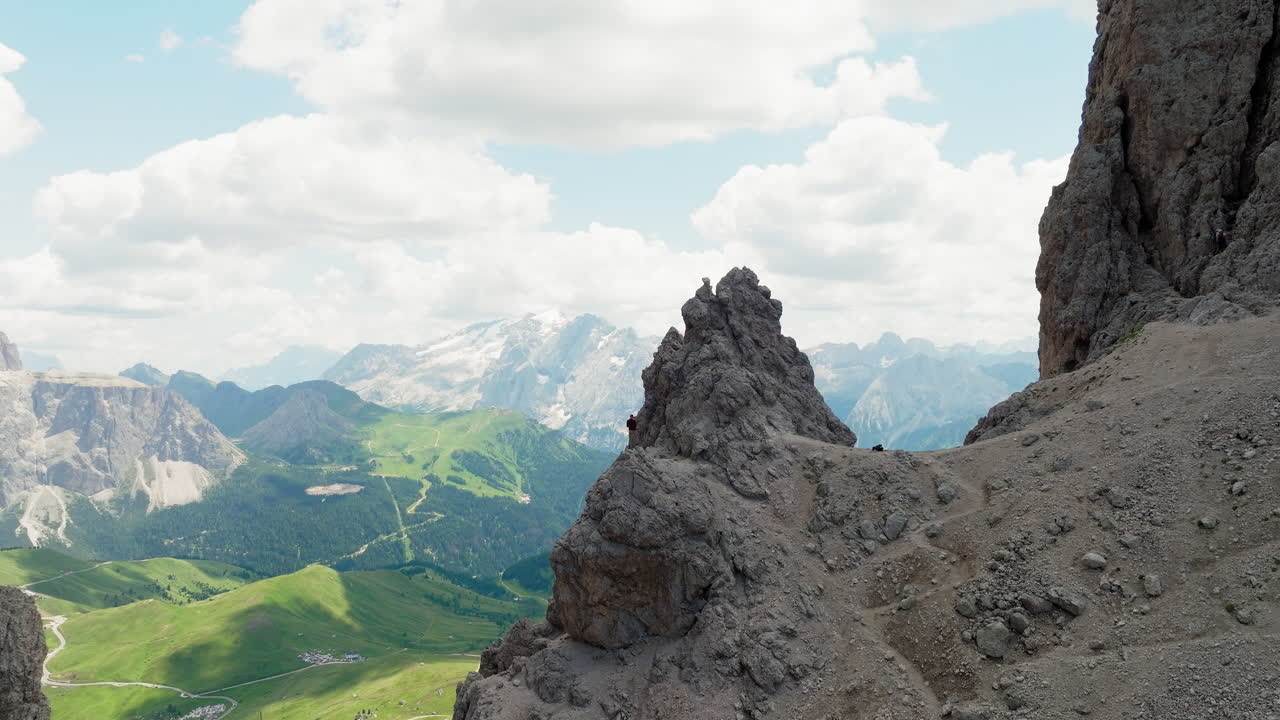 Slow panning drone shot of one man standing on top of Forcella del Sassolungo near Toni Demetz Hut, Dolomites, Italy