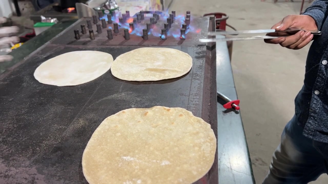 Roti mentah sedang dimasak di atas kompor.