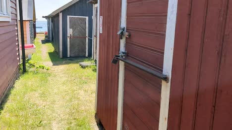 4k 60fps old fishing sheds with padlocks on harbor in sweden - tilt shot