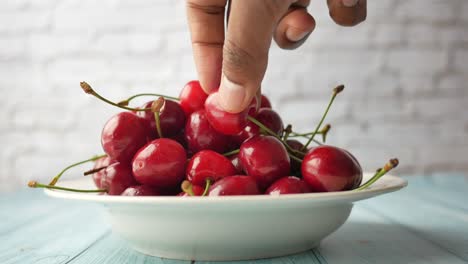 recogiendo cerezas a mano de un cuenco