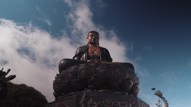 Statua gigante di Buddha contro un cielo blu nuvoloso in movimento