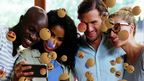 smiling diverse friends taking selfie with floating emoji animation