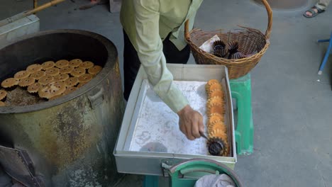 Mano-Del-Hombre-Sacando-Pasteles-Tailandeses-Portugueses-Tradicionales-Del-Horno-Y-Colocándolos-En-La-Bandeja,-Cámara-Lenta