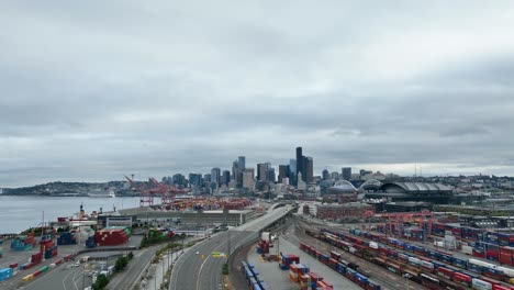 wide drone shot of seattle's shipping containers with the downtown skyscrapers off in the distance