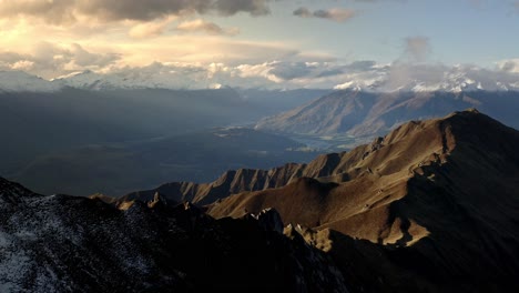 Sonnenlicht,-Das-Bei-Sonnenaufgang-Auf-Die-Berge-Scheint,-Wunderschöne-Hügel-Mit-Schnee-über-Einem-Tal,-Durch-Das-Ein-Fluss-Fließt