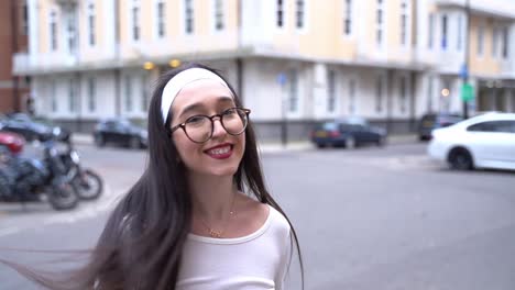 Beautiful-woman-turns,-hair-flips,-smiles-in-Soho,-London,-close-up-slow-motion