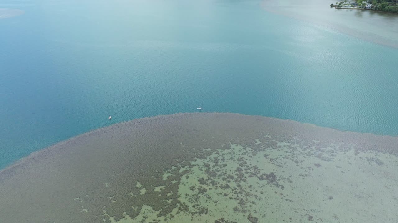 하와이의 이 많은 날에 오아후의 카네오헤에 있는 아톨을 오가는 스탠드업 패들 보더의 드론 영상