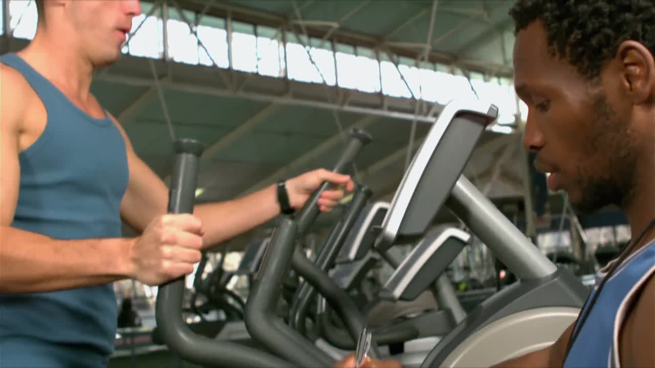 Uomo in forma che si allena in palestra con il personal trainer