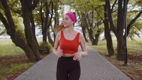 gimnasia atlética deporte corredor chica entrenamiento maratón correr, escuchar música en auriculares al aire libre parque