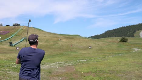 man practicing golf swing in open field