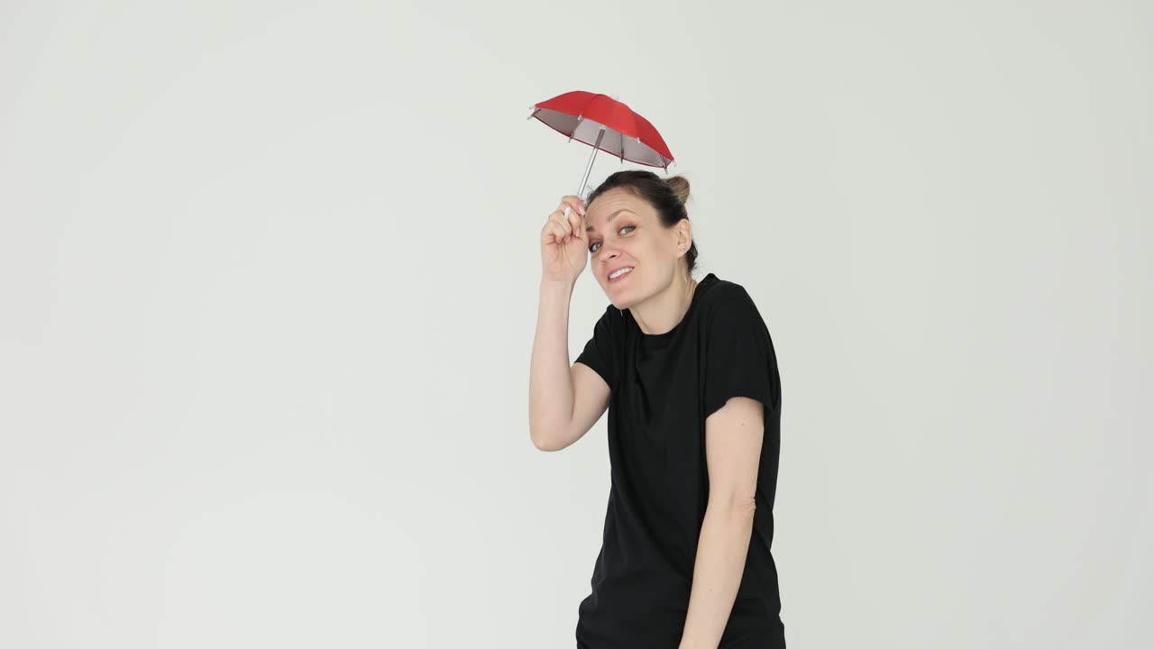 Woman holding red umbrella indoors