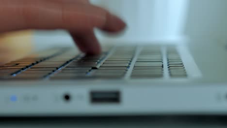 a close -up, male hands hit the keyboard of a laptop, print a text, a selective focus