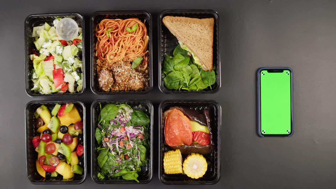 Healthy Meal Prep Containers with Smartphone Green Screen on Dark Background