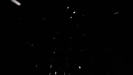 footage looking straight up at a dark sky with snow dramatically falling towards the camera