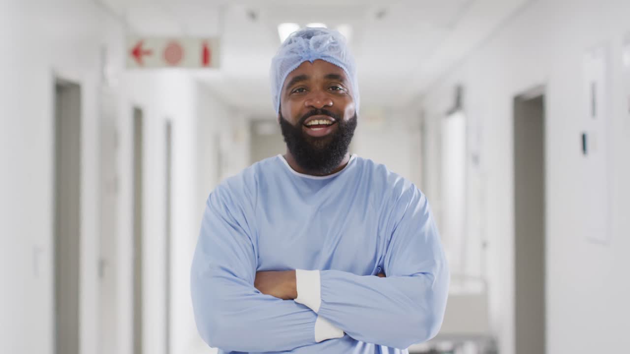 retrato de video de un médico afroamericano sonriente con gorra y bata quirúrgica, copia el espacio.