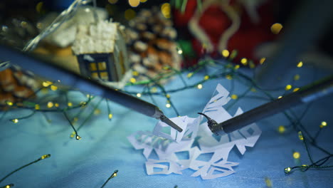 super presice robotic equipment used for decorating process. exquisite robotic arms deal with paper snowflake close up. christmas decoration at the backdrop.