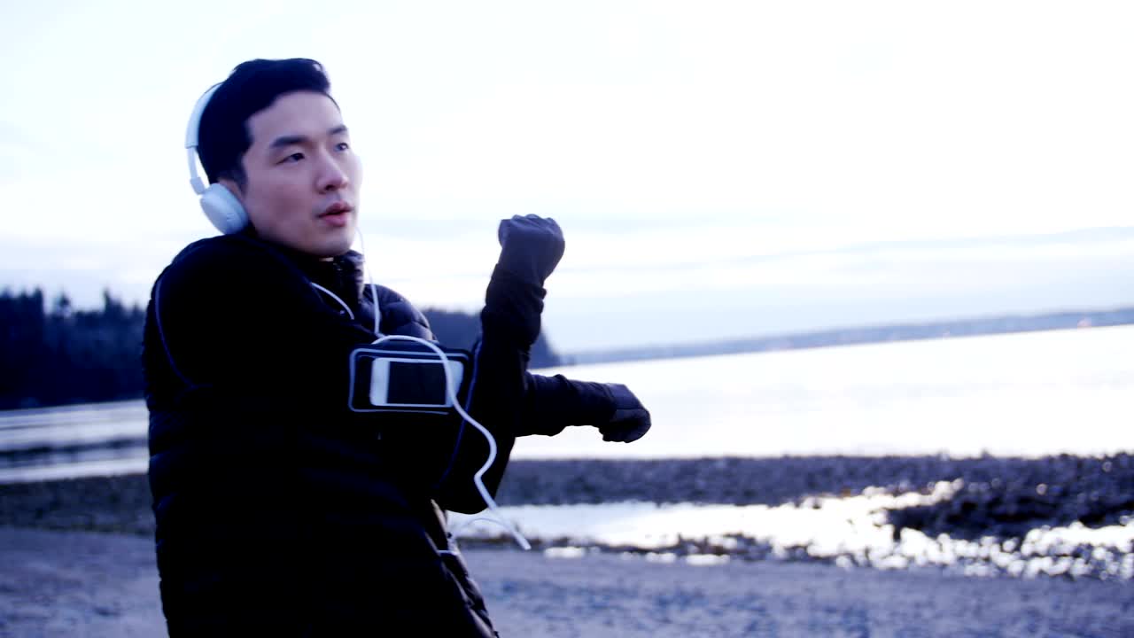 헤드폰 4k에서 음악을 들으면서 스트레칭 운동을 하는 남자