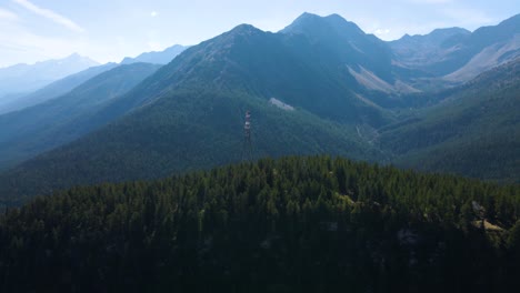 Disparo-De-Un-Dron-Volando-Alrededor-De-Una-Torre-De-Alta-Tensión-Situada-En-Lo-Alto-De-Una-Gran-Colina-En-Los-Alpes-Italianos