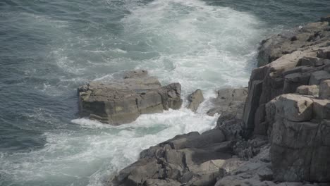 exterior diurno medio de olas rompiendo en rocas