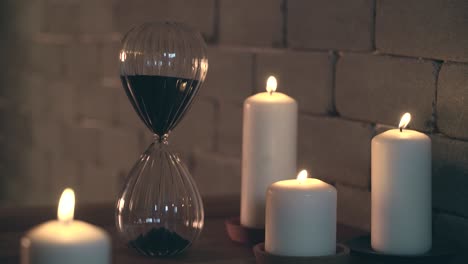 hourglass dropping sand and candles