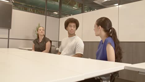 african american male, arab american female and caucasian female in their 20's in a meeting with video moving in