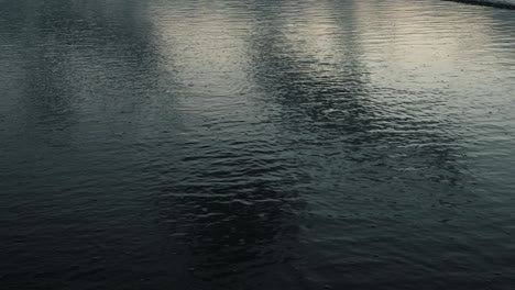 static timelapse of beach waves creating wet sand with reflections of moving clouds at dusk