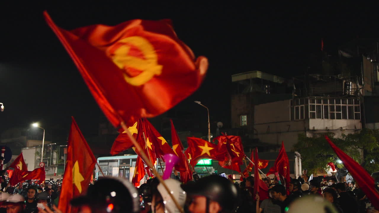 Crowd waving Vietnamese flags at night