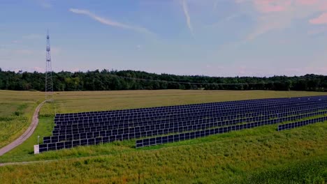 Rotating-aerial-view-of-solar-farm-among-lush-gold-and-green-fields