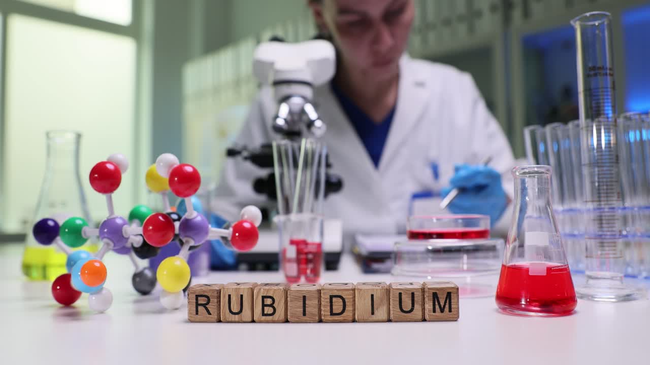 Cubi di legno compongono la parola rubidio in un luminoso laboratorio scientifico, con un medico.