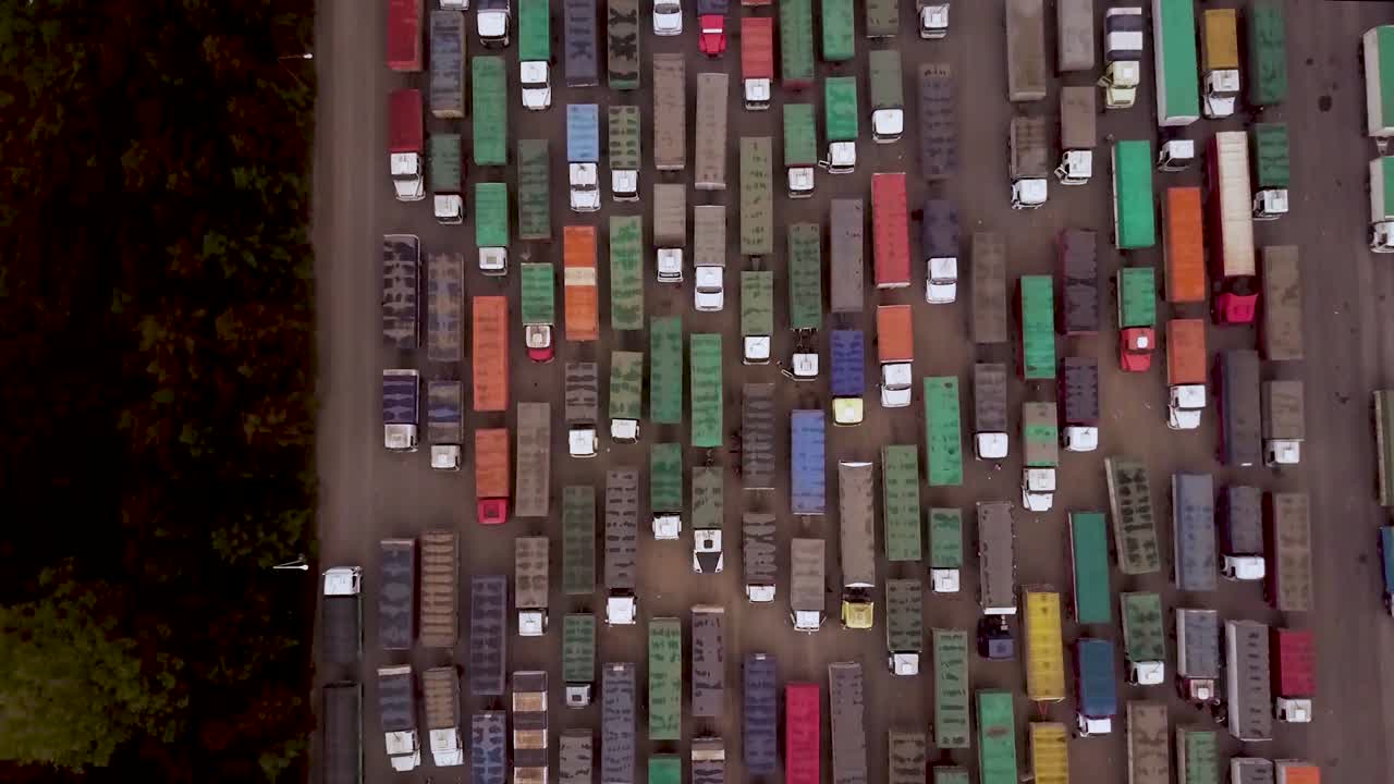 Aerial top view of colorful cargo trucks in lot